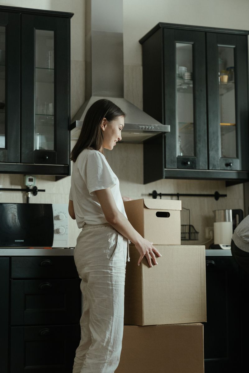 Family unpacking moving boxes together in their new home kitchen